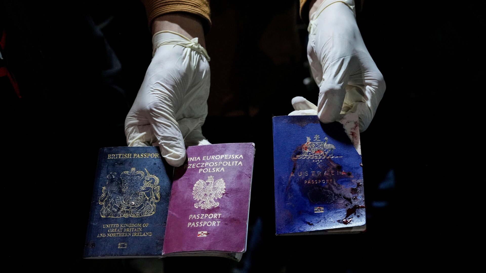 Un hombre muestra pasaportes británicos, polacos y australianos manchados de sangre después de un ataque aéreo israelí en Deir al-Balah, la Franja de Gaza, el lunes abril   1, 2024.