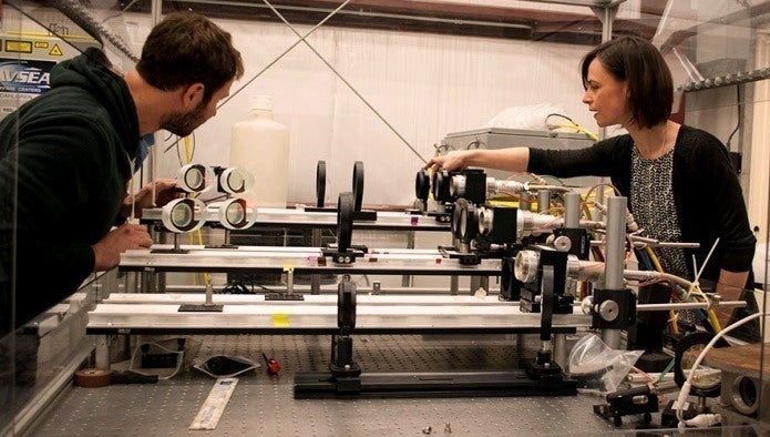 Los científicos del Centro de Guerra de Superficie Naval de la División Dahlgren (NSWCDD) Chris Von Hohenleiten y Emily Martin se preparan para una prueba de letalidad con láser asegurándose de que las ópticas están alineadas correctamente en abril de 2017. 