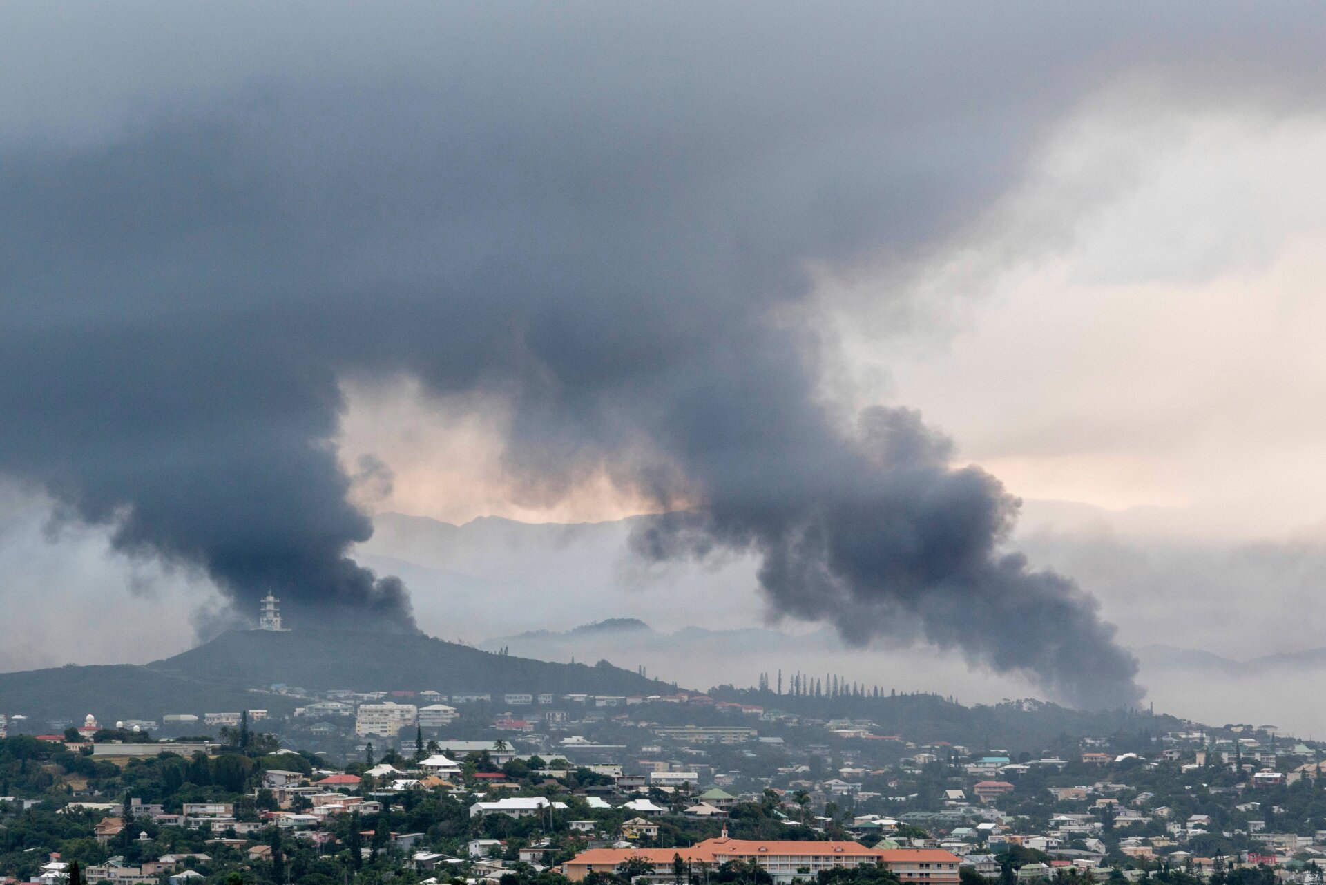 El humo se eleva a lo lejos en Noumea, Nueva Caledonia, el 14 de mayo de 2024.