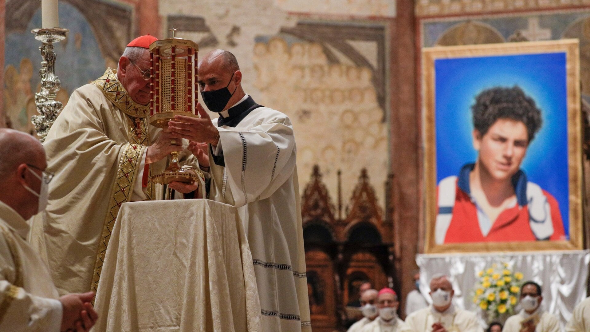 El cardenal Agostino Vallini, izquierda, sostiene una reliquia de Carlo Acutis, de 15 años, un niño italiano que murió en 2006 de leucemia, durante Su ceremonia de beatificación se celebró en la Basílica de San Francisco, en Asís, Italia, el 10 de octubre de 2020.