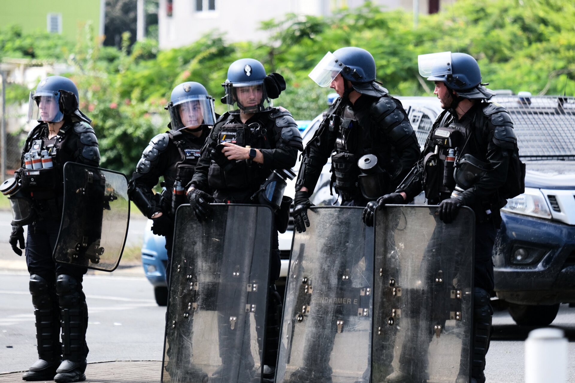 La policía francesa se encuentra con sus escudos en la entrada del distrito de Vallee-du-Tir, en Noumea, el 14 de mayo de 2024.