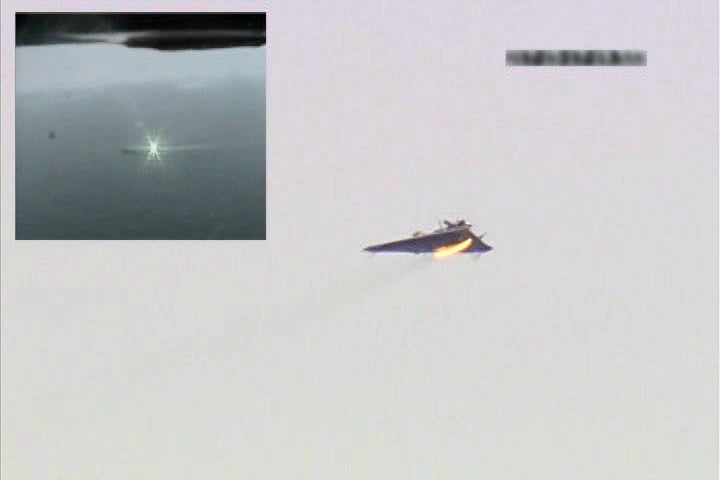 Una imagen fija de video muestra una vista en pantalla dividida del Sistema de armas láser (LaWS), arriba izquierda, alcanzando un objetivo controlado remoto  aviones en 2012. 