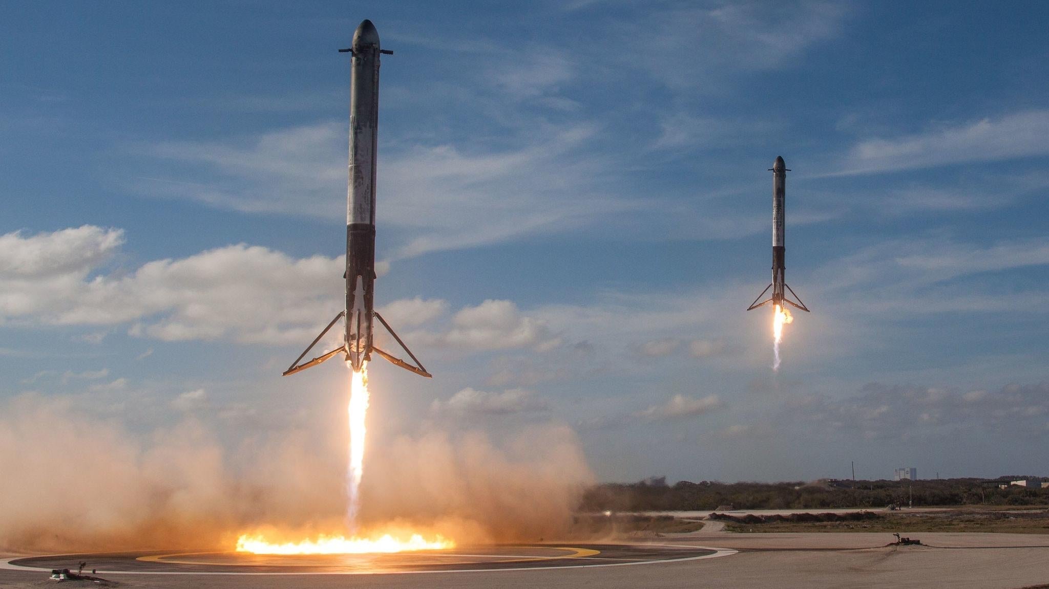 Un par de propulsores laterales Falcon Heavy que regresan para aterrizar durante el vuelo inaugural del cohete en 2018.