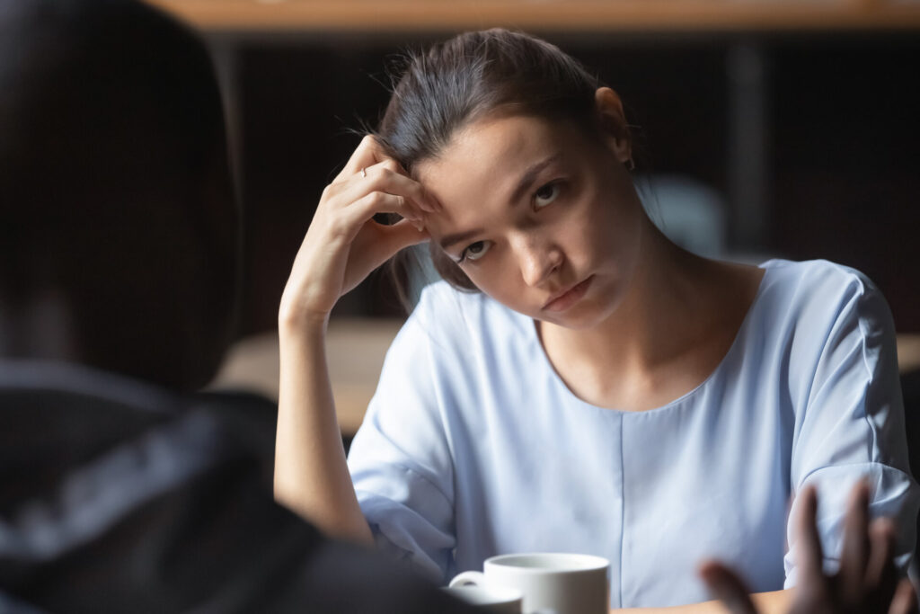 Bored,unhappy,girlfriend,listening,to,african,american,boyfriend,in,cafe,