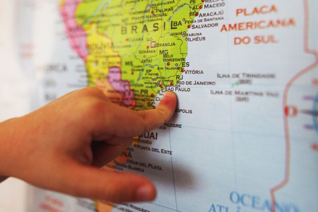 Alumno Señalando Un Punto En Sudamerica En Un Mapa