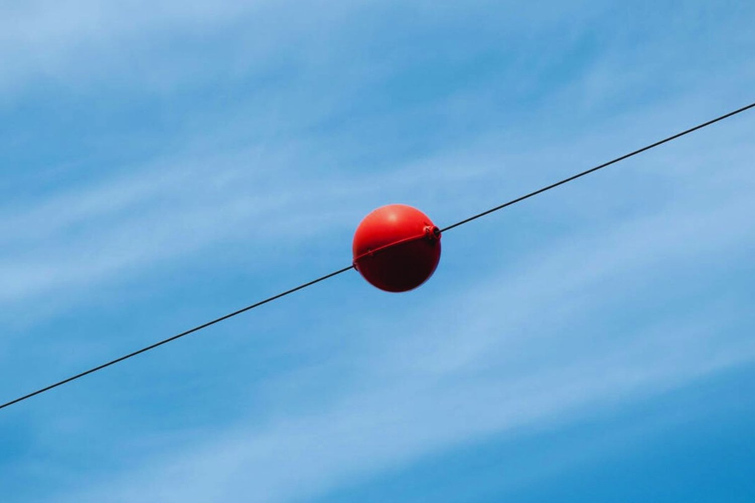 Las misteriosas bolas rojas en los cables no son lo que crees: su verdadero propósito podría salvarte la vida