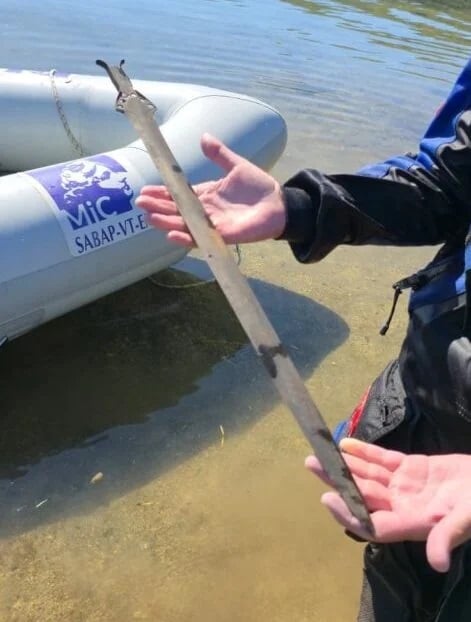 Researcher Holds Sword From Mezzano Lake E1793286460496